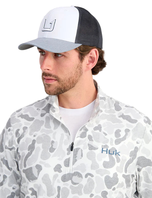 Man wearing a white and gray cap with a logo, and a white and gray camouflage jacket with a brand logo.
